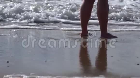 赤足的女人站在海边的沙滩上一阵一阵地涌进她的脚自我反省孤独视频的预览图