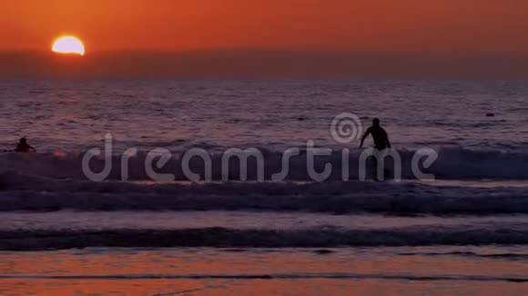 在圣克莱门塔圣克莱门塔的橙色粉红色日落和太阳耀斑木墩上冲浪视频的预览图