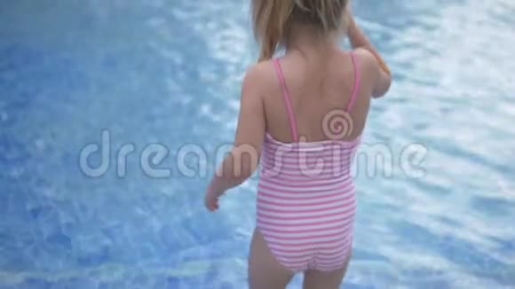 一个穿着条纹泳衣的小女孩走进游泳池视频的预览图