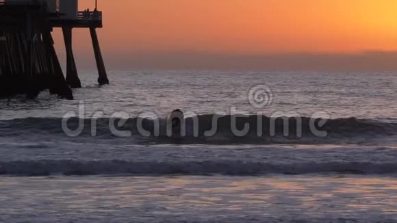 在加州圣克莱门塔的橙色粉红色日落和太阳耀斑木码头冲浪视频的预览图