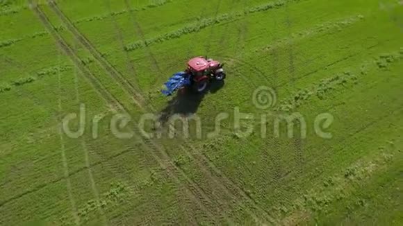 骑在绿色农田上的红色拖拉机从上往下拍视频的预览图