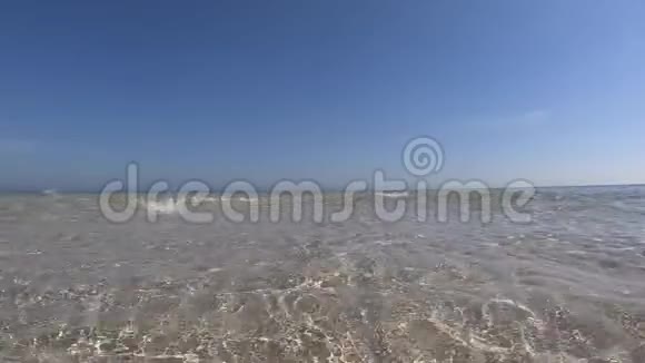水晶般清澈的浅水和白沙带蓝天的慢动作视频的预览图