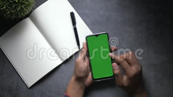 人手告智能手机绿色屏幕的俯视图视频的预览图