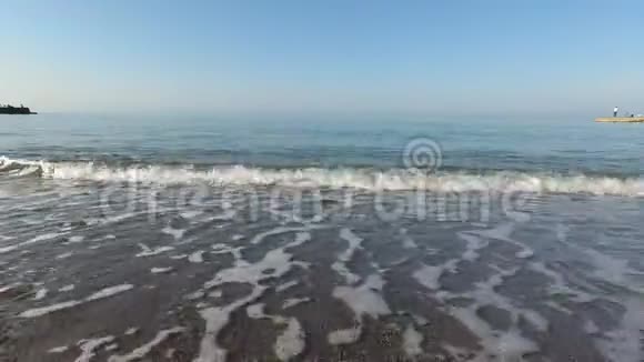 平静的大海卵石滩上的弱波视频的预览图