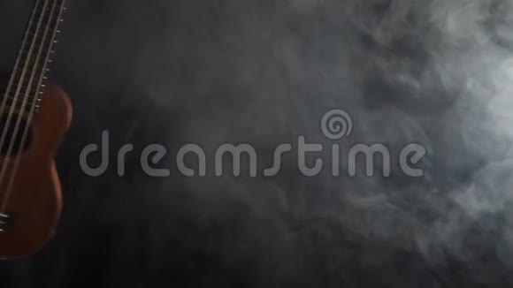 红木夏威夷四弦琴吉他在黑色背景下与烟雾隔离视频的预览图