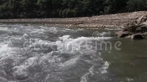 靠近道路的河流快速流动的水视频的预览图