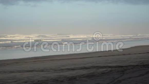 新西兰穆里瓦伊日出时黑色沙滩上出现了小海浪视频的预览图