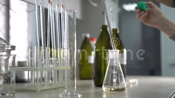 工厂分析实验室一名女性实验室助理将液体混合在玻璃瓶中特写镜头视频的预览图