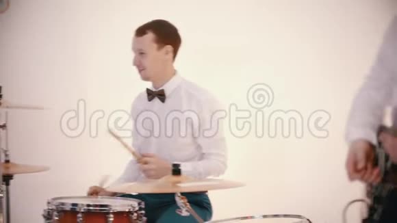 一支音乐乐队演奏一首歌男人穿着白衬衫姜女穿着蓝色裙子唱歌视频的预览图