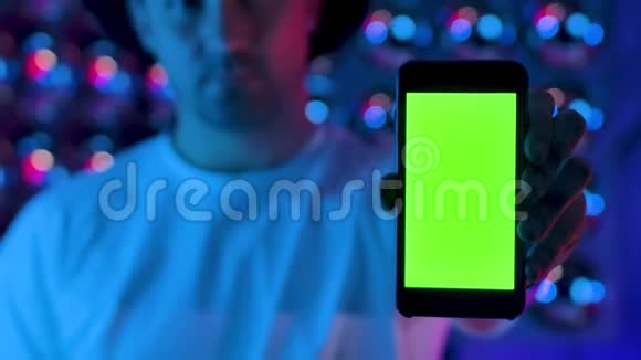 使用手机的人呈现绿色屏幕色度键垂直显示发光视频的预览图