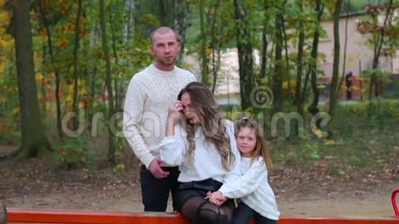 一家人坐在秋千上摆姿势视频的预览图