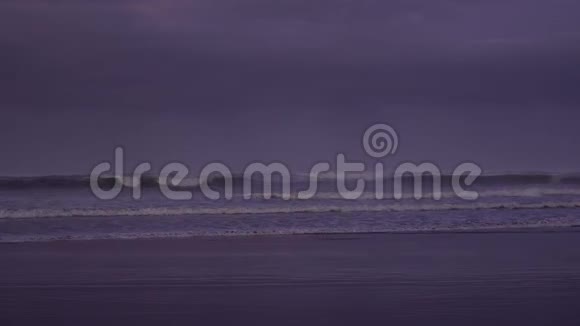 新西兰穆里瓦伊黎明前黑色沙滩上的小海浪拍打着视频的预览图