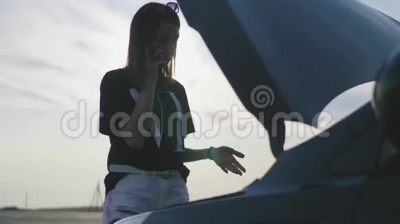 欧洲商界女性在路上撞车女司机在乡间小路上摔倒使用智能手机视频的预览图