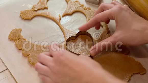 女人在桌上用心形刀切姜饼面团视频的预览图