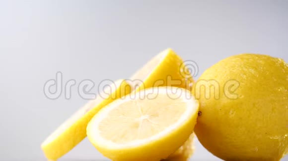新鲜柠檬片在灰色背景下缓慢旋转柠檬与滴水视频的预览图