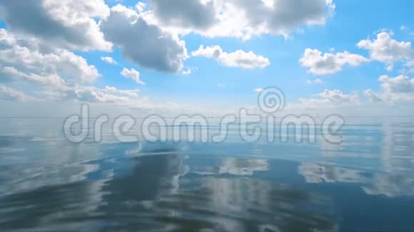 抽象地反射出水面水面上有小涟漪地平线上有一片多云蓝色的天空视频的预览图