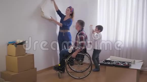 友好的家庭心爱的残疾父亲坐在轮椅上有着慈爱的妻子和可爱的孩子选择新的壁纸视频的预览图