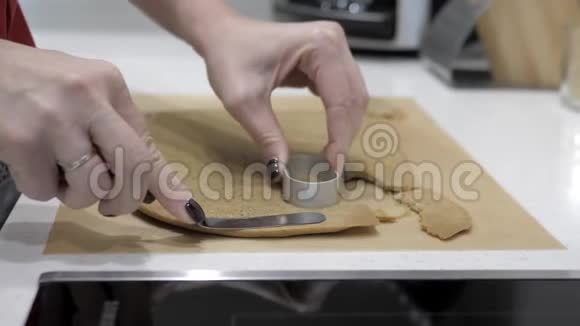 女性的手在金属模具和铲子的帮助下在纸杯蛋糕上切割了一个椭圆形视频的预览图