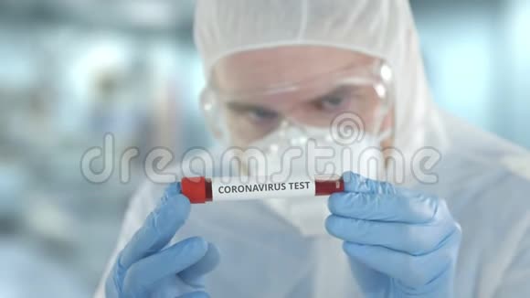 非聚焦实验室助理穿着防护服用冠状病毒测试检查小瓶视频的预览图