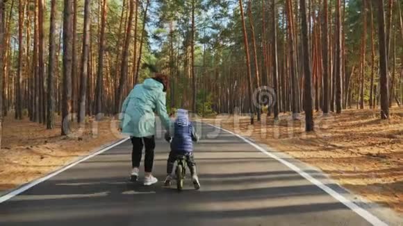 妈妈教小儿子在路上骑平衡自行车视频的预览图