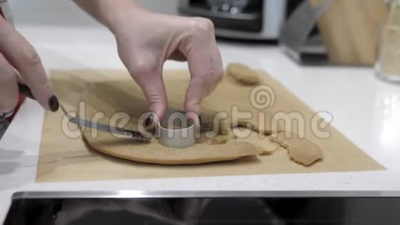 女性的手在金属模具和铲子的帮助下在纸杯蛋糕上切割了一个椭圆形视频的预览图