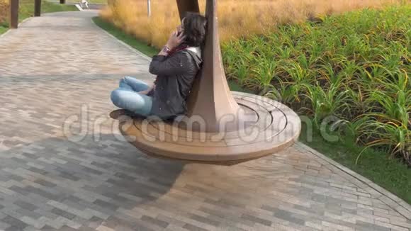 秋天高加索女人骑着旋转木马在电话里说话视频的预览图
