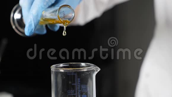 实验室化学实验专家实验室玻璃管中手套混合配料专家的特写视频的预览图