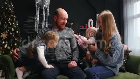 新年爸爸在沙发上抱着他的孩子和妻子视频的预览图