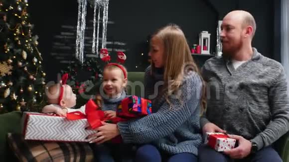 新年一家人看着他们的礼物微笑着视频的预览图