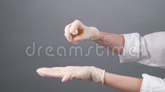 戴一次性手套的女医生在上面喷防腐剂药妇消毒橡胶手套COVID19视频的预览图