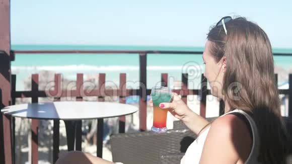 一个女人检查了她被带到海滩酒吧的鸡尾酒视频的预览图