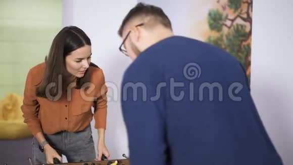 女孩和男人一起玩桌上曲棍球视频的预览图