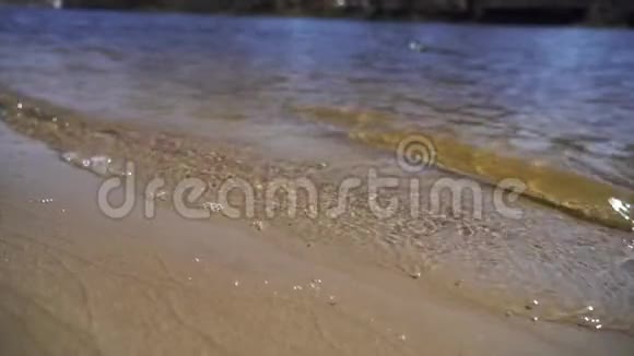 水晶清澈的水和金色的沙子缓慢移动视频的预览图