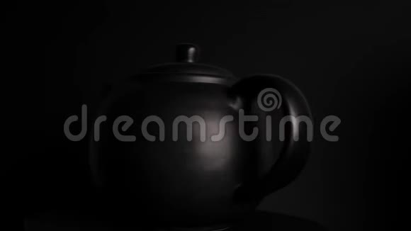 黑色酿造茶壶在黑暗背景下旋转无缝循环视频的预览图