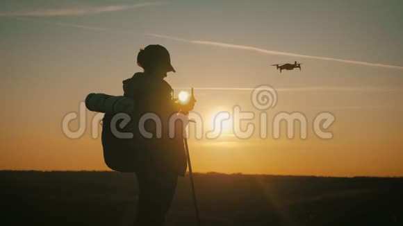 女游客在旅途中驾驶飞机日落时分在山上的旅行者的剪影视频的预览图