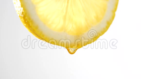 在白色背景下缓慢地从柠檬片中滴下蜂蜜视频的预览图