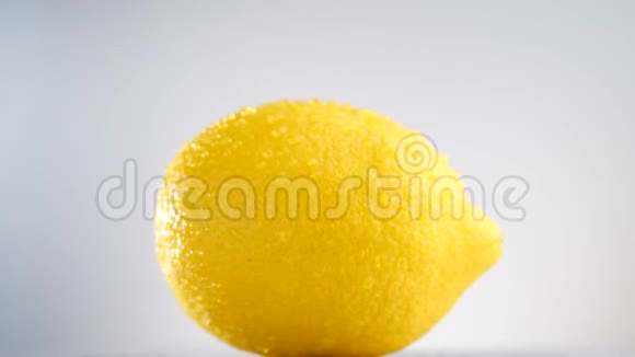 新鲜柠檬在白色背景上旋转柠檬与滴水视频的预览图