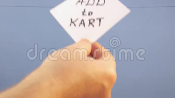 一个男人挂着一张白色的纸上面有黑色的铭文在蓝色的背景上添加到卡丁车上视频的预览图