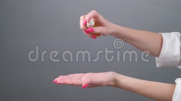 女人正在她的手上喷洒防腐剂用于清洁双手近距离观看COVID19视频的预览图