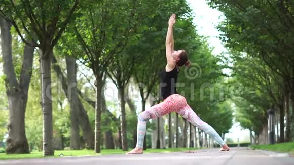 布鲁内特年轻女子在公园小巷慢动作做瑜伽视频的预览图