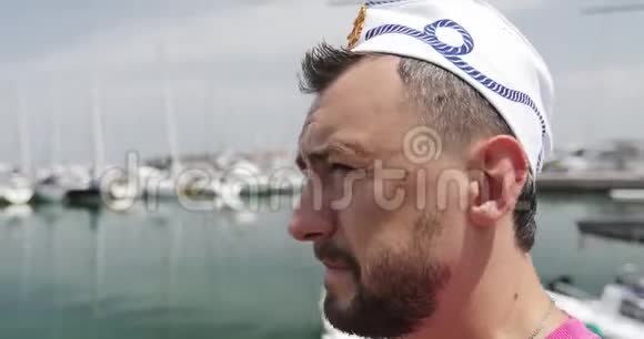 一个戴着水手帽留胡子的人沿着码头走视频的预览图