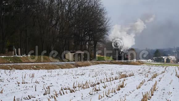 蒸汽机和乘用车沿阿米什农场土地在第一次下雪后视频的预览图