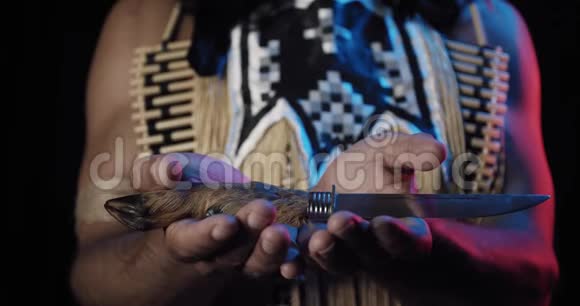 一个美国土著男子手拿着一把羊蹄刀用于刀柄视频的预览图