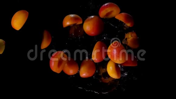 辣杏的两半正在飞起来黑色背景上溅起水花视频的预览图