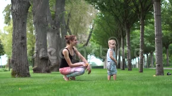 年轻的妈妈在公园里慢动作地拥抱着她的孩子视频的预览图