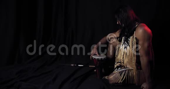 美国原住民留着长发穿着传统服装摸着鼓视频的预览图