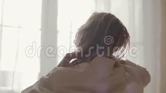 特写后景的性感白种人女孩触摸头发在阳光下早上在家醒来的年轻女子视频的预览图