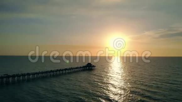 日落时水上码头的黑暗轮廓视频的预览图