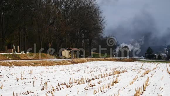 蒸汽机和乘用车沿阿米什农场土地在第一次下雪后视频的预览图