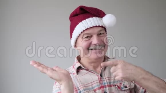 自信的内容戴着圣诞帽的西班牙老人食指指向一边视频的预览图